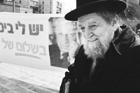 Un judío ultraortodoxo pasa delante de una pancarta del líder del Likud, Ariel Sharon.